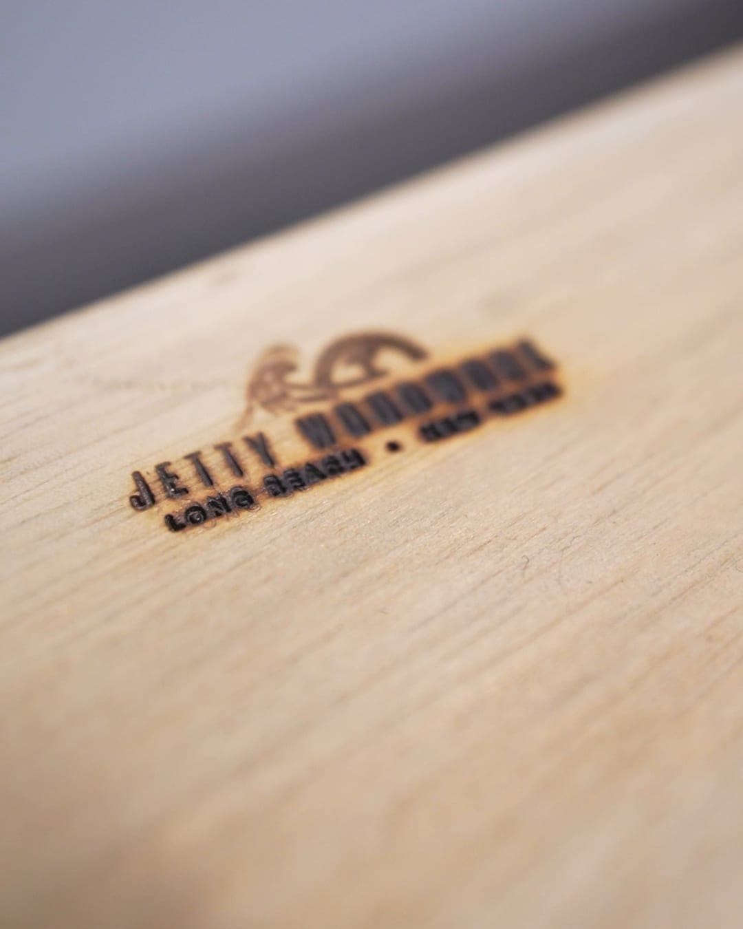 Jetty Woodwork logo burned into the top of a light wood table