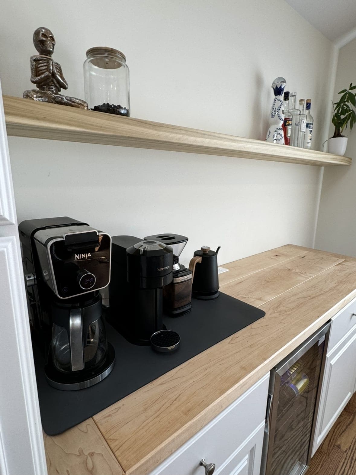 Coffee bar with a light wood floating shelf above a butcher-block counter