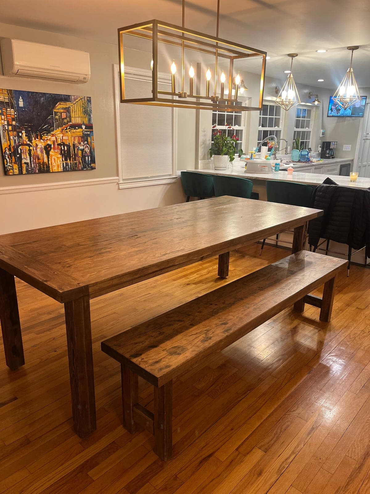 Farmhouse dining table and matching bench under a brass chandelier