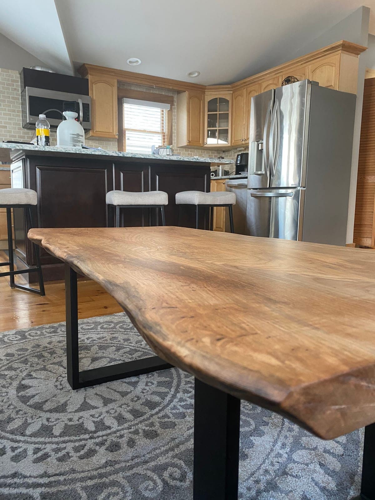 Live-edge wood table on a black steel base in a kitchen