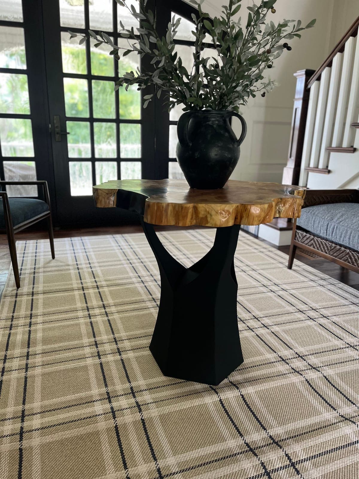 Round live-edge wood table on a black pedestal base in an entry hall